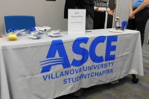 A white-clothed table labeled Villanova University ASCE (for American Society of Civil Engineers) is set up for an event.